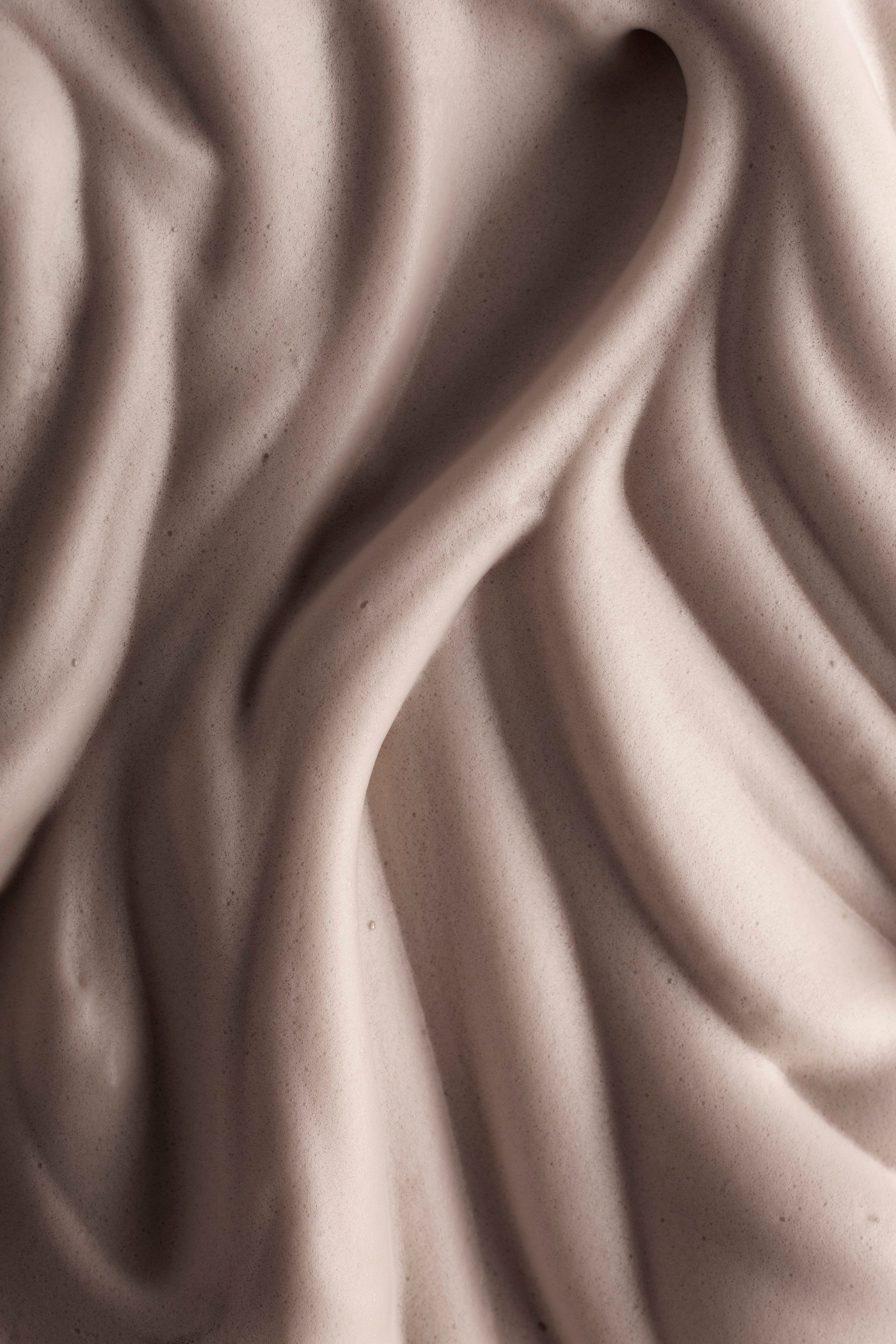 Close-up of smooth, beige-colored fabric with wavy texture